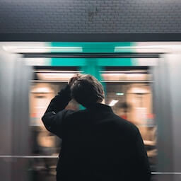 Jeune homme attendant le métro vu de dos